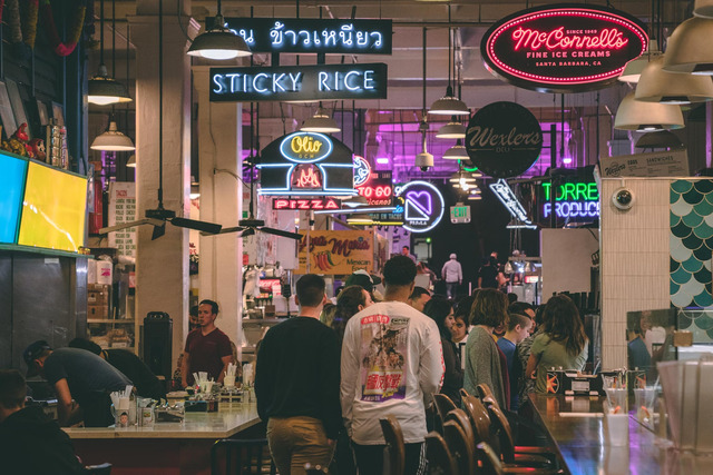 Imagem da fila de um restaurante com placas neon